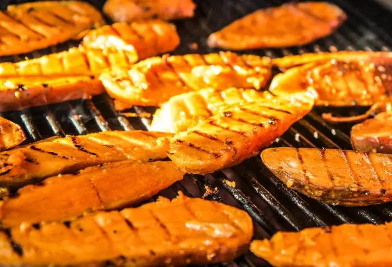 Spiced grilled sweet potato halves with char marks on the grill grates of a Hasty Bake Charcoal Grill