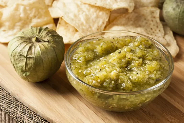 Pit Buddies smoked salsa verde in a glass bowl with tomatillos and tortilla chips, made on a Hasty Bake Charcoal Grill