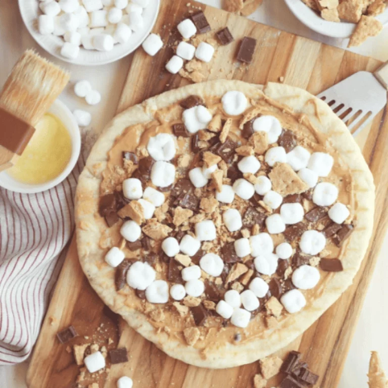 Grilled peanut butter s'mores pizza topped with marshmallows, chocolate chunks and crushed graham crackers, grilled on a Hasty Bake Charcoal Grill